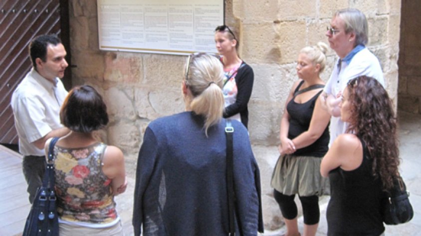 Els/les touroperadors/es escolten atentament unes explicacions.