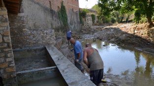 Veïns en la tasca d'ajudar a netejar els desperfectes de la inundació