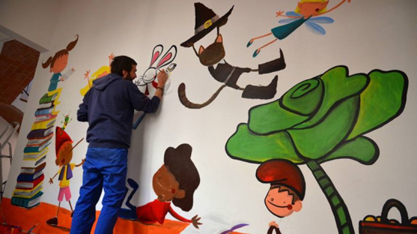 L’il·lustrador Joan Turu pintant el mural