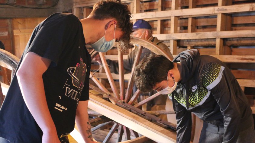 Dos alumnes fent tasques de restauració d'un carro