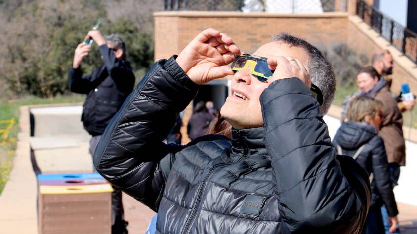 Un home observa l'eclipsi solar amb ulleres homologades des del Parc Astronòmic del Montsec